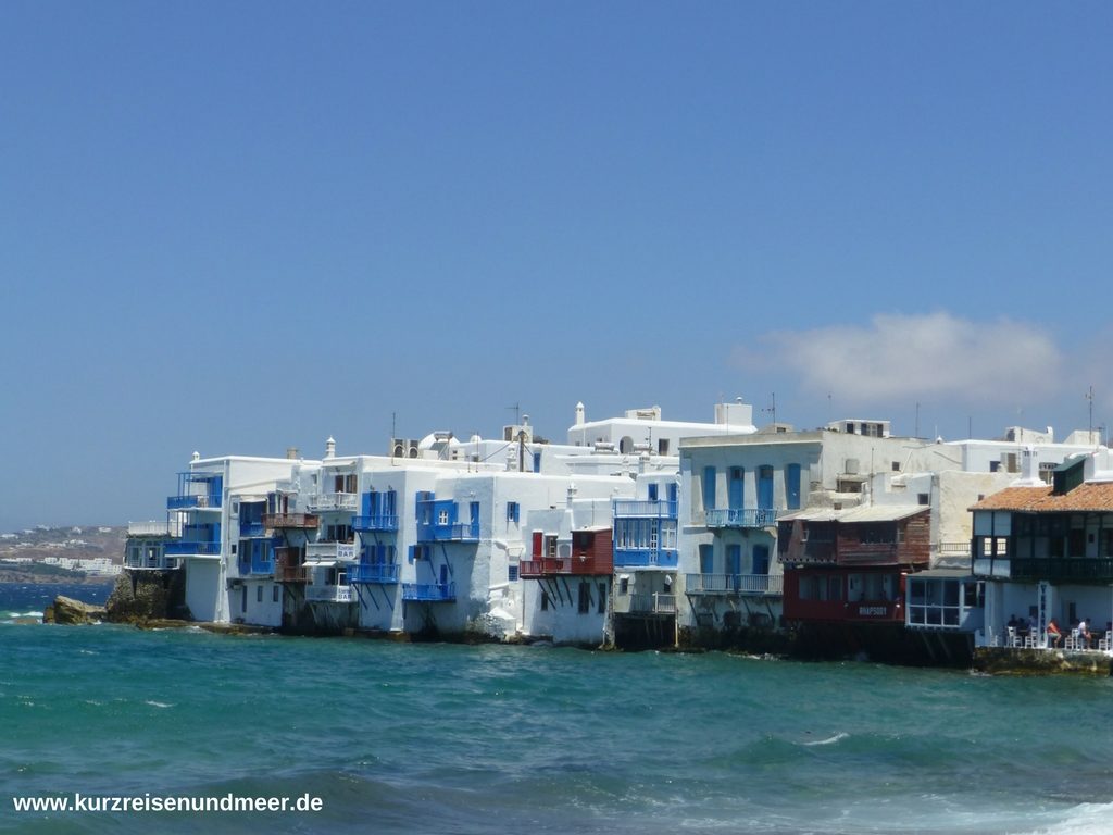 Das Bild zeigt Häuser in Mykonos Stadt direkt am Wasser